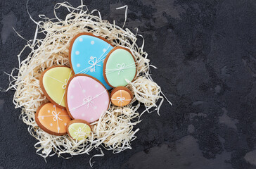 Easter card with gingerbread cookies. Easter spring decorative composition with nest and gingerbread cookies in form of eggs on gray background.