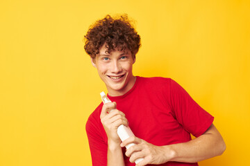 Young curly-haired man detergents home care posing isolated background unaltered