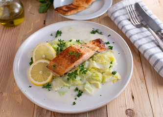 Fish with cabbage and bechamel sauce on a plate
