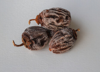dried dates on a white background ; Its Turkish name is persimmon and persimmon.