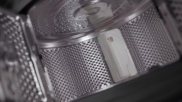 Old generation top-loading open drum washing machine. The camera flies out of the washing machine
