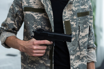 Pistol i an armed man. camouflage. weapon, armed man, gun, military patrol. Man in camouflage is armed with pistol