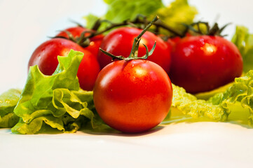 Tomatoes red and green lettuce on white background