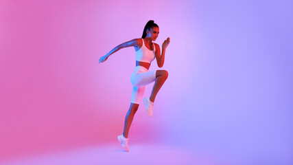 Fototapeta na wymiar Sporty Woman Jumping Exercising Posing Over Neon Background, Panorama