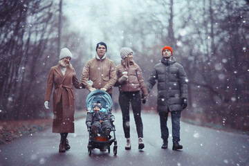 winter walk in the park, young family with a small child and friends, young parents outside...