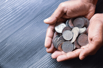 Handful of Indian currency coins on grey textured background. Investment or donation concept. Top view, copy space.