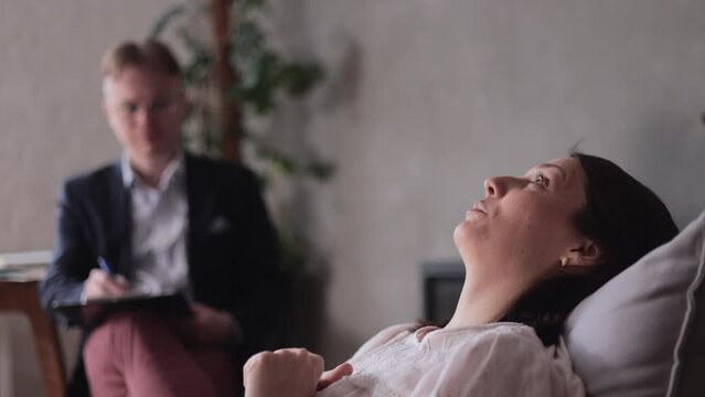 a male psychologist conducts a patient's appointment in his office. a woman tells a therapist about her panic attacks and mental disorders. depression treatment and psychotherapy session for mental