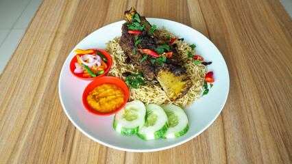 Indian beef rib biryani served on a white plate on the table. Selective focus & Free Photo