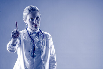 A female doctor threatened with her index finger on a blue background. Treatment. Patient consultation. Hospital