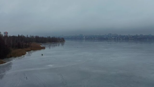 Drone shot of the fisherman fishing on the ice lake 6