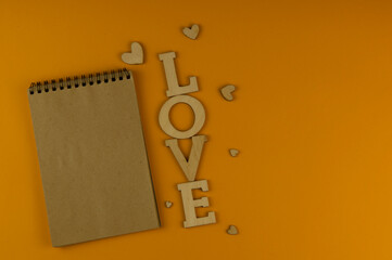 Love word, small hearts on colorful paper background. Top view of Valentine's Day.