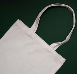   Mock-up eco friendly beige or white color  canvas cotton fabric tote bag on dark green ...