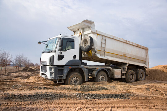 construction dump truck performs excavation work on a construction site. Soil unloading. Preparatory earthworks before construction