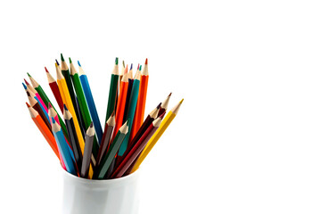 Colored pencils in a white mug isolated on a white background. close-up, copy space