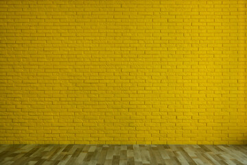Empty room with yellow brick wall and wooden floor