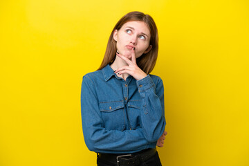 Young English woman isolated on yellow background having doubts while looking up