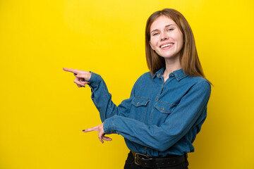 Young English woman isolated on yellow background pointing finger to the side and presenting a...