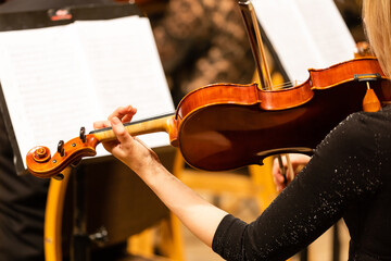 Symphony orchestra on stage, hands playing violin