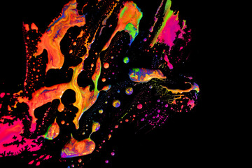 Abstract vibrant multi-color wet paint drops and splotch on black background. Bright orange and...
