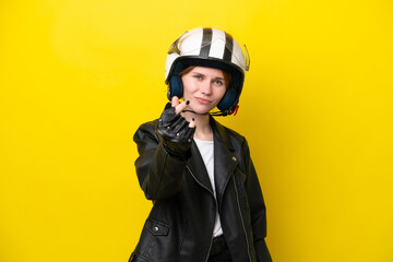 Young English woman with a motorcycle helmet isolated on yellow background making money gesture