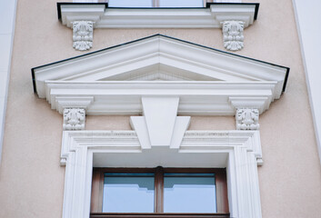 The upper part of the window of the neoclassicism style with a complex design of the facade with wooden frame. Old building in Lviv, Ukraine. © shchus