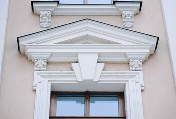 The upper part of the window of the neoclassicism style with a complex design of the facade with...