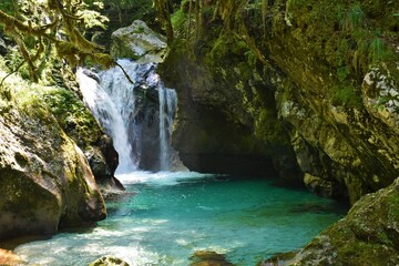 Fototapeta na wymiar Waterfall in Sunik water grove in Lepana in Julian alps and Triglav national park, Slovenia flowing into a pool bellow