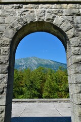 Fototapeta na wymiar View of mountain Krasji Vrh framed by an stone arched entrance near Kobarid in Littoral region of Slovenia