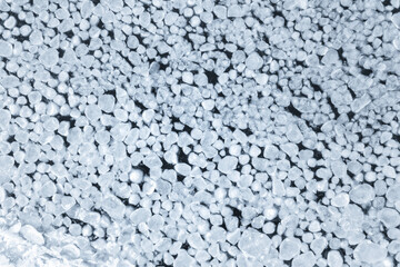 abstract texture of broken ice and dark water. background of the frozen surface of a clean lake or river