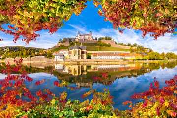 Wurzburg. Main river waterfront and scenic Wurzburg castle and vineyards reflection view through autumn leaves - obrazy, fototapety, plakaty