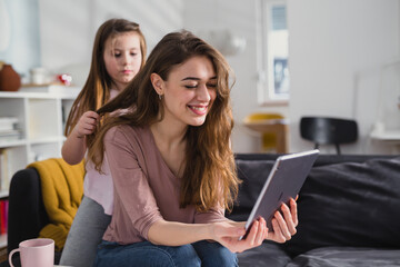 mother and daughter using digital tablet at home