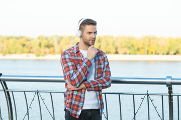 listening audio book. stylish handsome man in casual checkered shirt.