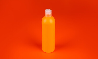 shampoo bottle on orange background, beauty product