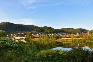 Fototapeta na wymiar View of the town of Sevnica with Sava river in front and forest covered hill behind in Stajerska, Slovenia