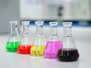 The Erlenmeyer or Conical flask on bench laboratory, with colorful solvent solution from titration experiment, acidity, alkalinity, and total hardness analysis compounding in wastewater sample.