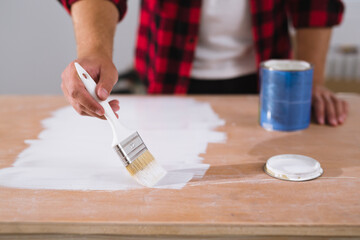 close up of man painting door in white paint