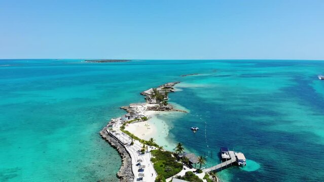 Aerial footage of the beautiful Pearl Island in the Bahamas near Nassau, showing the beach and lighthouse of the island of the amazing tropical island and clear blue ocean waters around the island