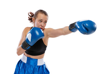 Dynamic portrait of young girl, professional boxer practicing in boxing gloves isolated on white...
