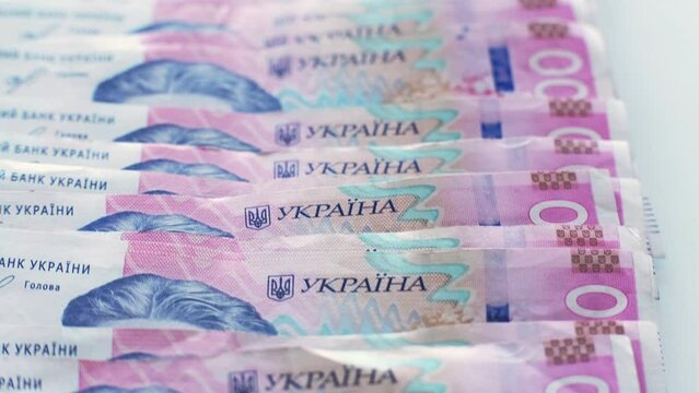 Money background. Ukrainian hryvnia. UAH foreign currency. 200 hrn bill pink blue paper banknotes cash pile isolated on white.