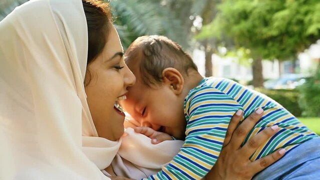 Mother and little son spending time together at the park. Muslim family outdoor in Dubai. Lifestyle moments in the UAE