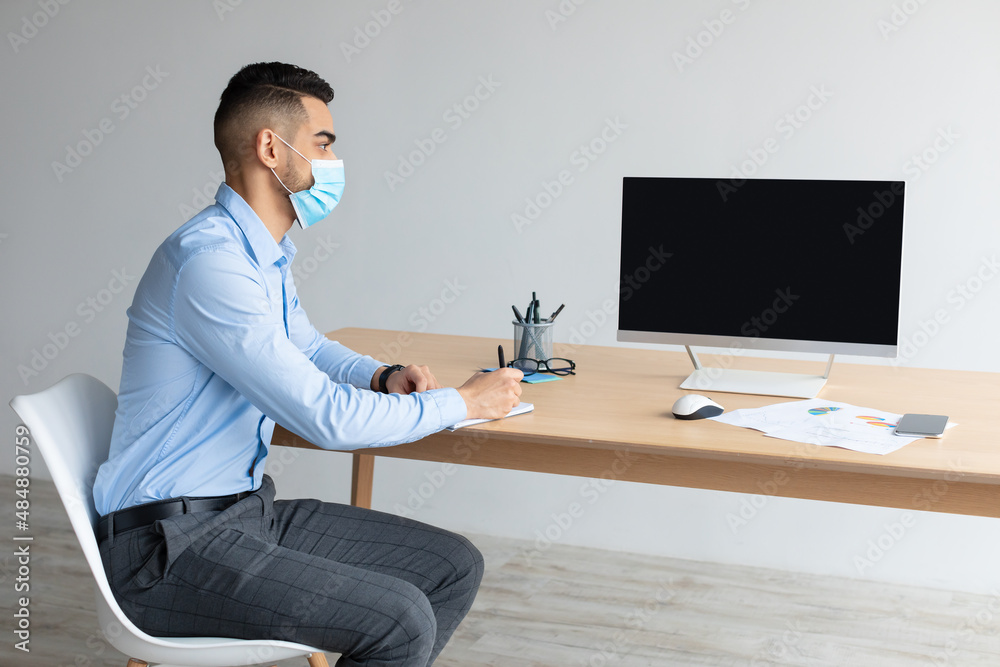 Aufkleber arab worker in facemask using laptop with empty screen, mockup