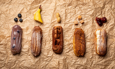 Different types of delicious eclairs and their ingredients decorated on a paper