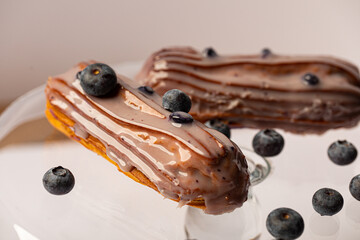 Creamy eclairs with blueberry friuts served on a tray 