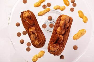 French eclairs with chocolate and peanuts sprinkled with cocoa