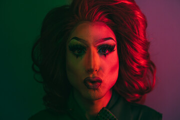Drag queen looking at camera with neon color lights inside studio - Lgbtq and pride concept