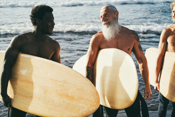 Multi generational surfer men having fun on the beach - Focus on senior man face