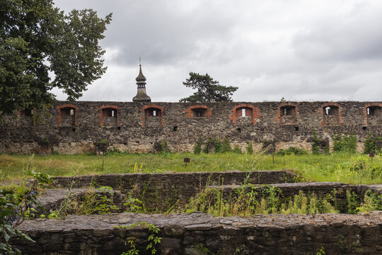 Medieval Gray Castle wall of ancient Uzhgorod castle with a green lawn in front. Uzhgorod castle, Zakarpattya region, Western Ukraine