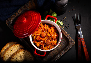 braised cabbage with sausage on a dark background