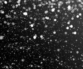 Falling snowflakes on night sky background, black background.