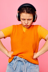 portrait of a young woman grimace headphones entertainment emotions music pink background unaltered